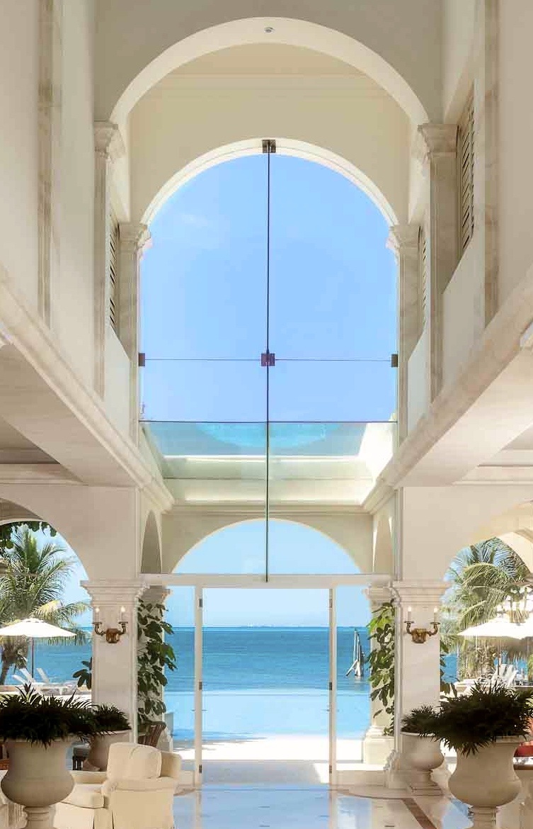Villa Architecture, Interior Design and Turn-key by Jerry Jacobs Design © three story Atrium view vanishing edge pool and ocean beyond. The Engineered glass opening and loggia glass top, survived hurricanes.