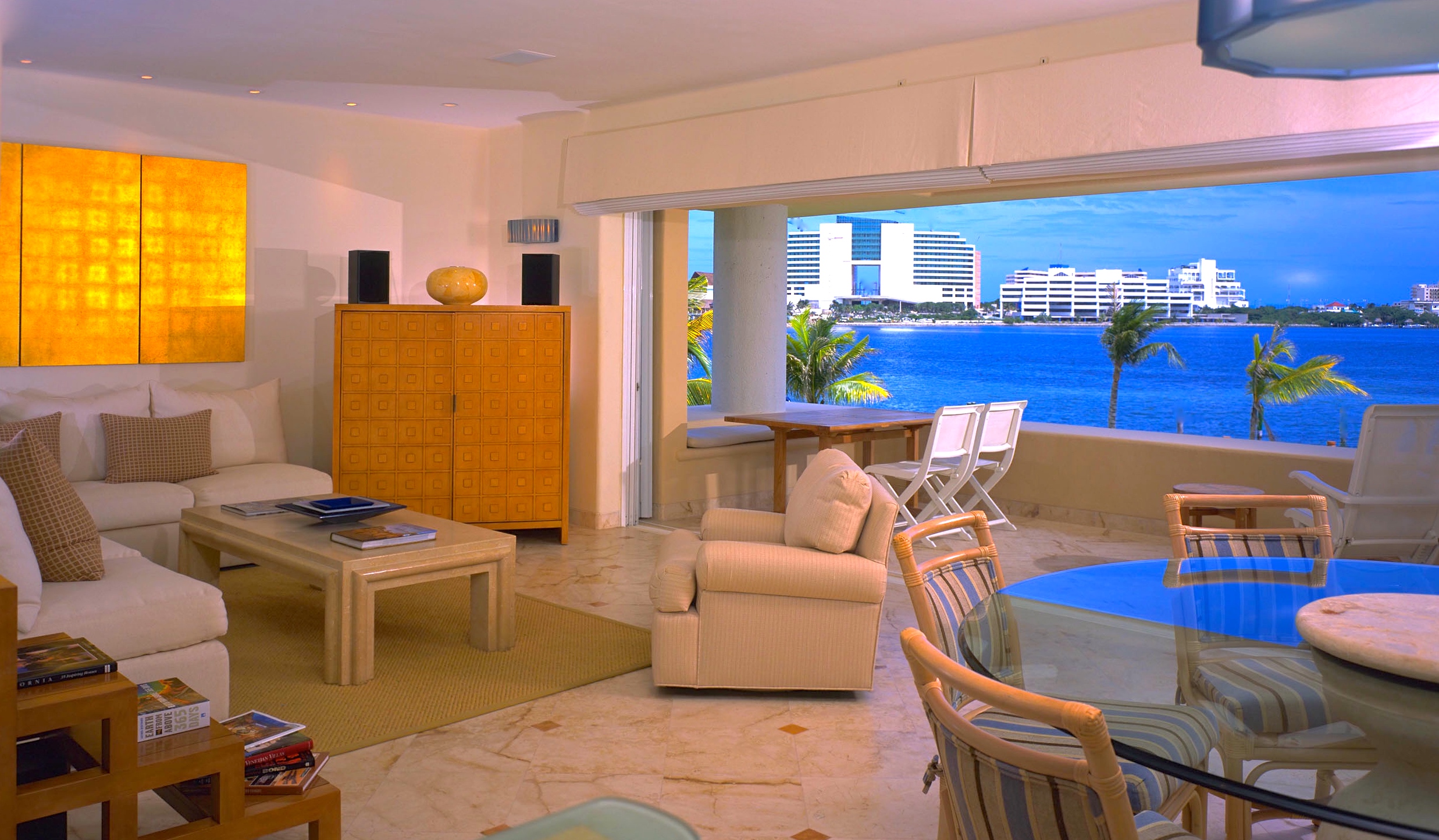 Vacation Condo Interiors. Living room and dining room Ocean view, soft pink walls and wicker furniture at Cancun, Mexico Condo G, a Jerry Jacobs Design ©