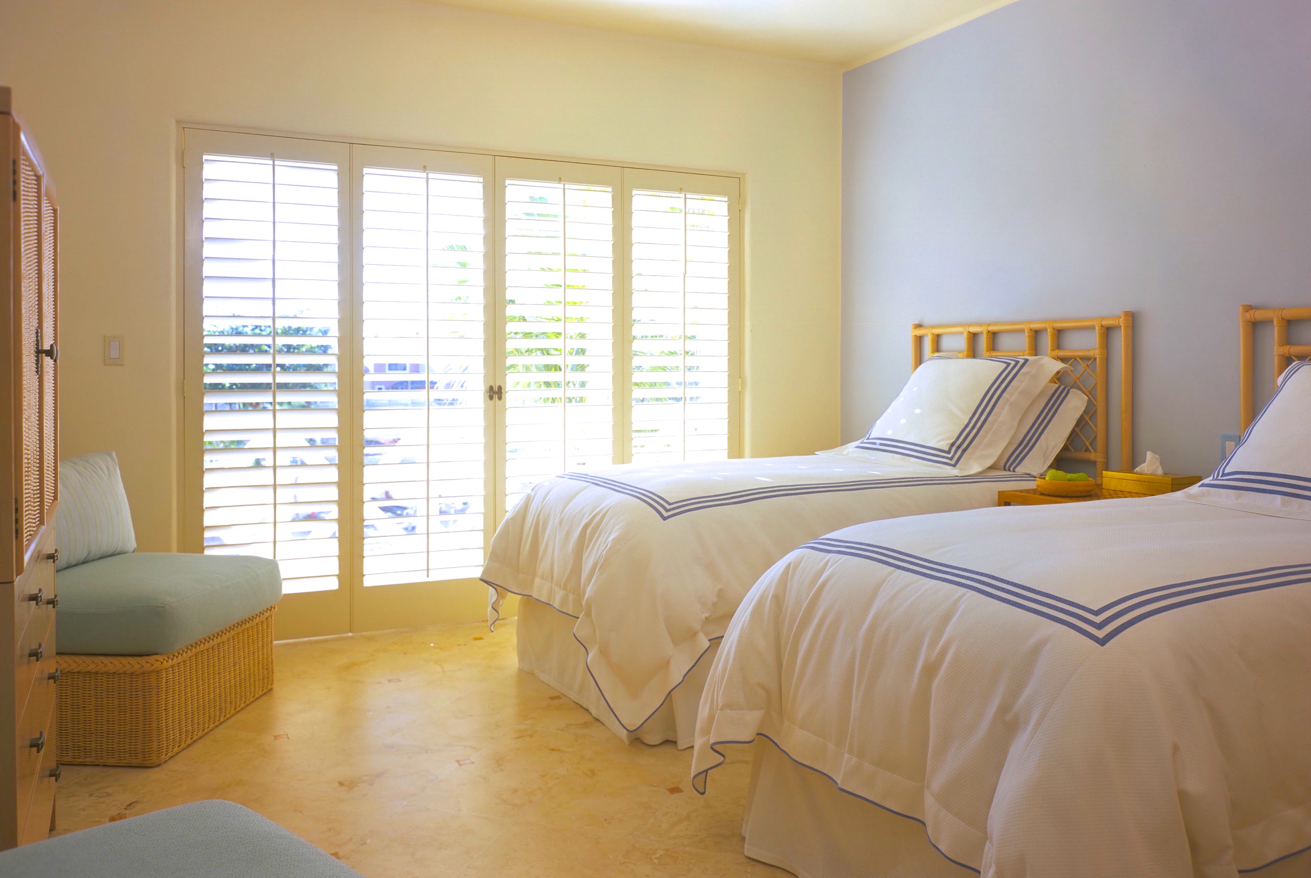 Vacation Condo Interiors. Guest bedroom, shutters, ratan headboards, Pratessi linens at Cancun, Mexico Condo G, a Jerry Jacobs Design ©