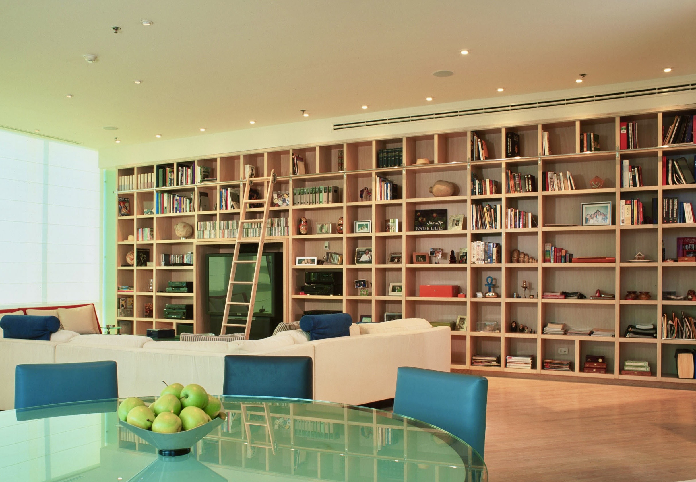 A custom JerryJacobsDesign © library wall in Monterrey, MX.Seating and rolling ladder..