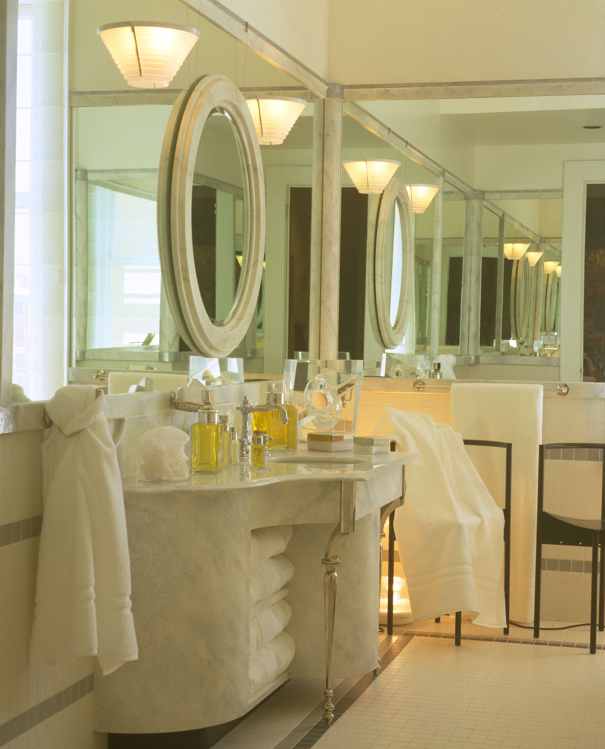 A bathroom with two mirrors and a sink