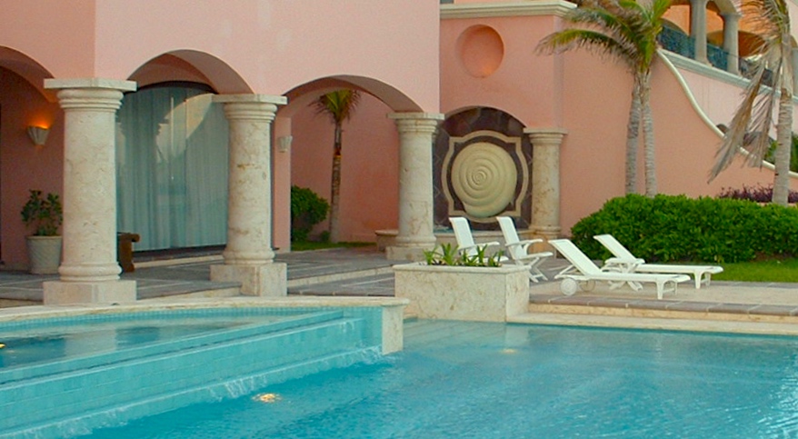 A pool with chairs and a palm tree in the background.