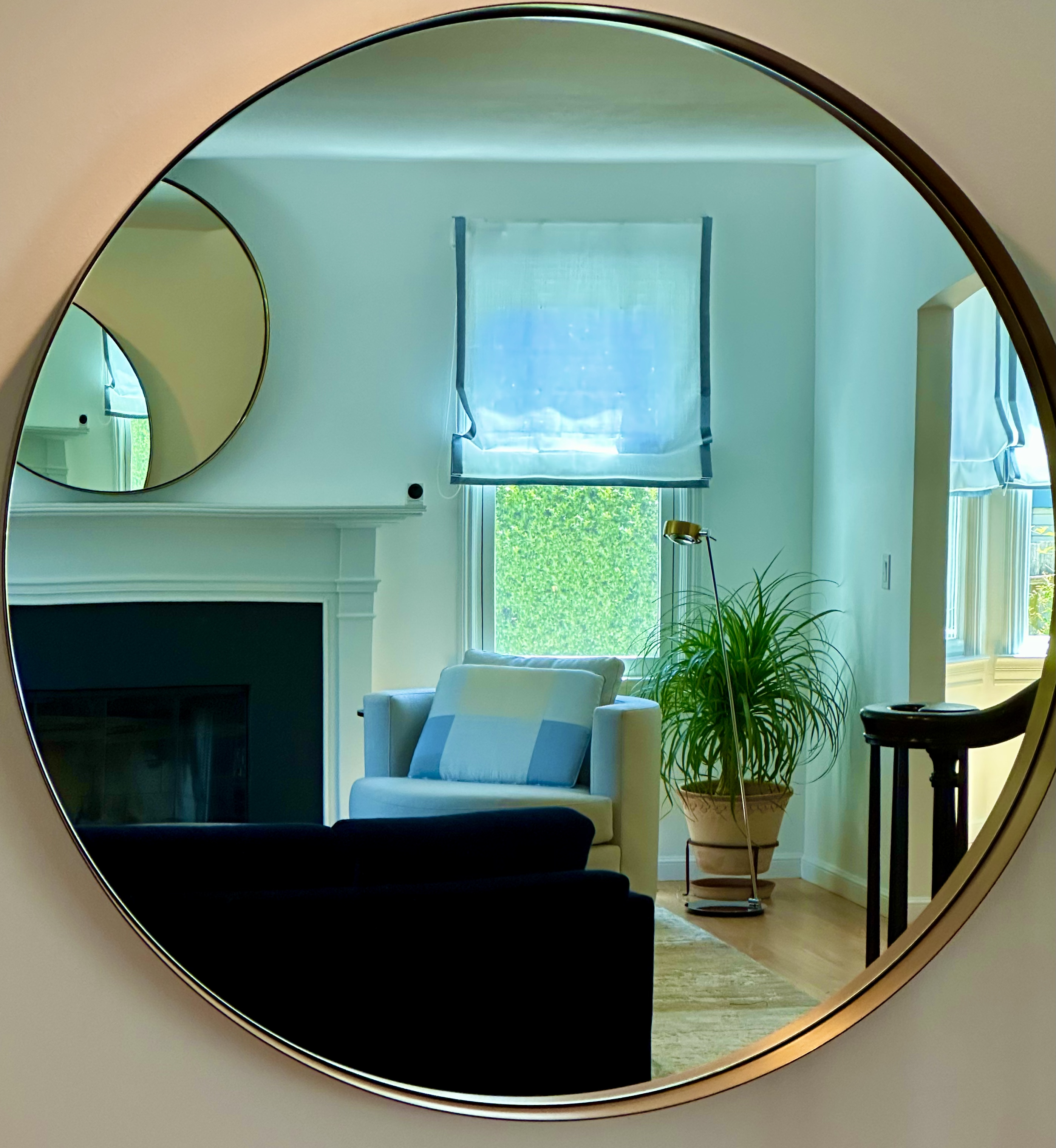 Larkspure CA, home Interiors. Living Dining layout shows furniture and window covering reflected on the larger of the two one round mirrors, se the samller one above fireplace.